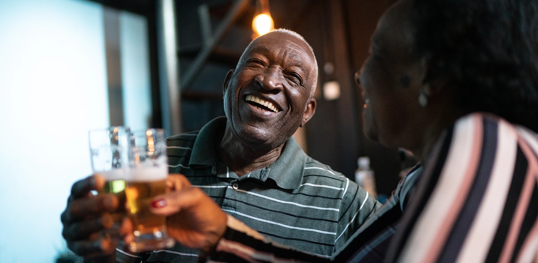 older couple saying cheers with a glass of beer